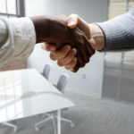 Two people shaking hands at a job interview.
